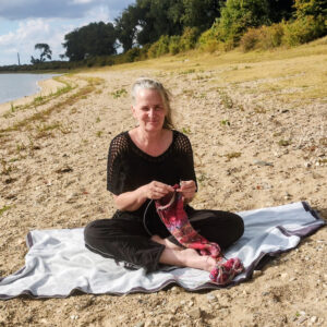 Hipsypixie zittend op een handdoek aan het haken op het strandje van de bisonbaai